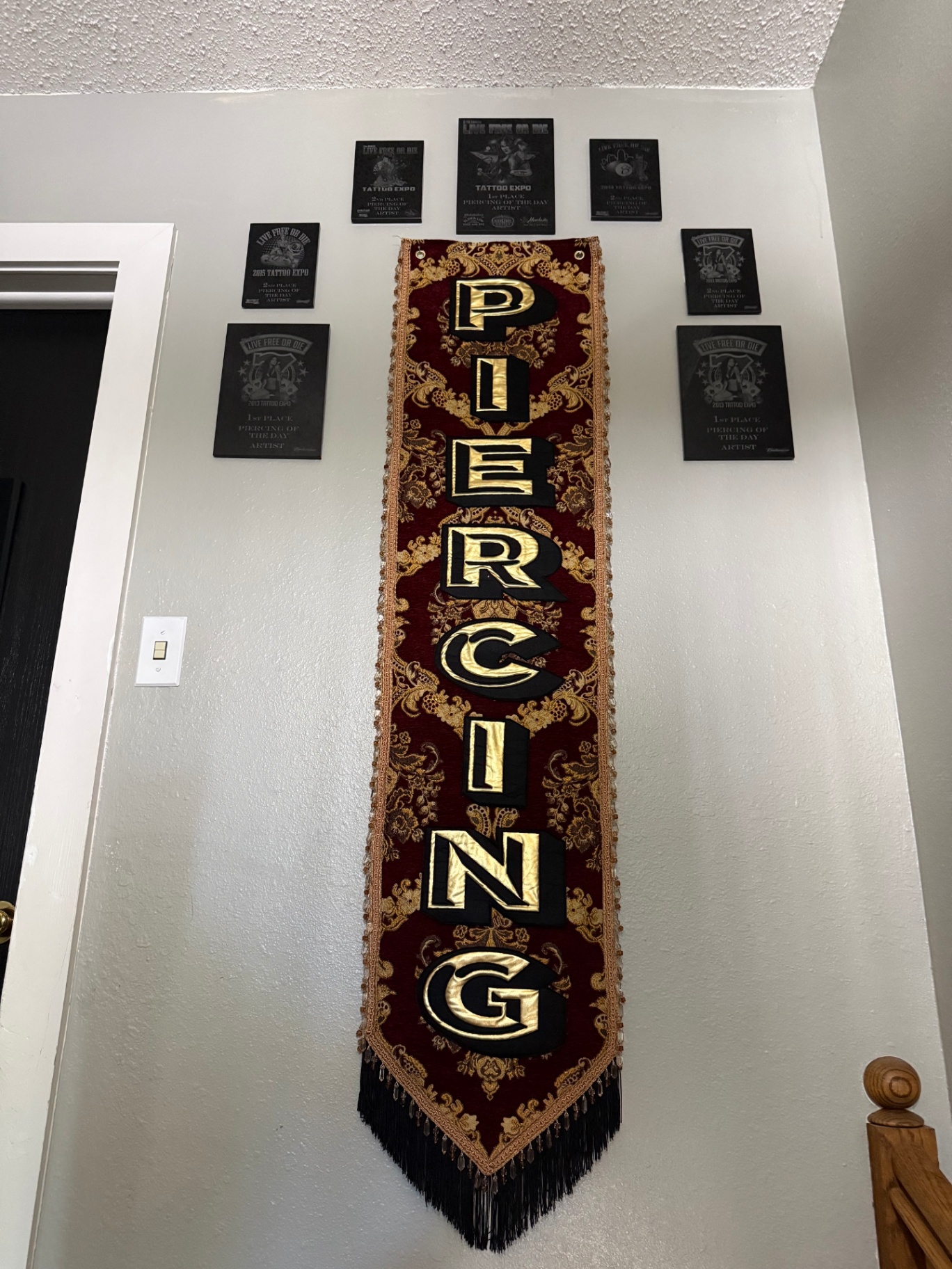 Piercing banner and award plaques above the piercing station
